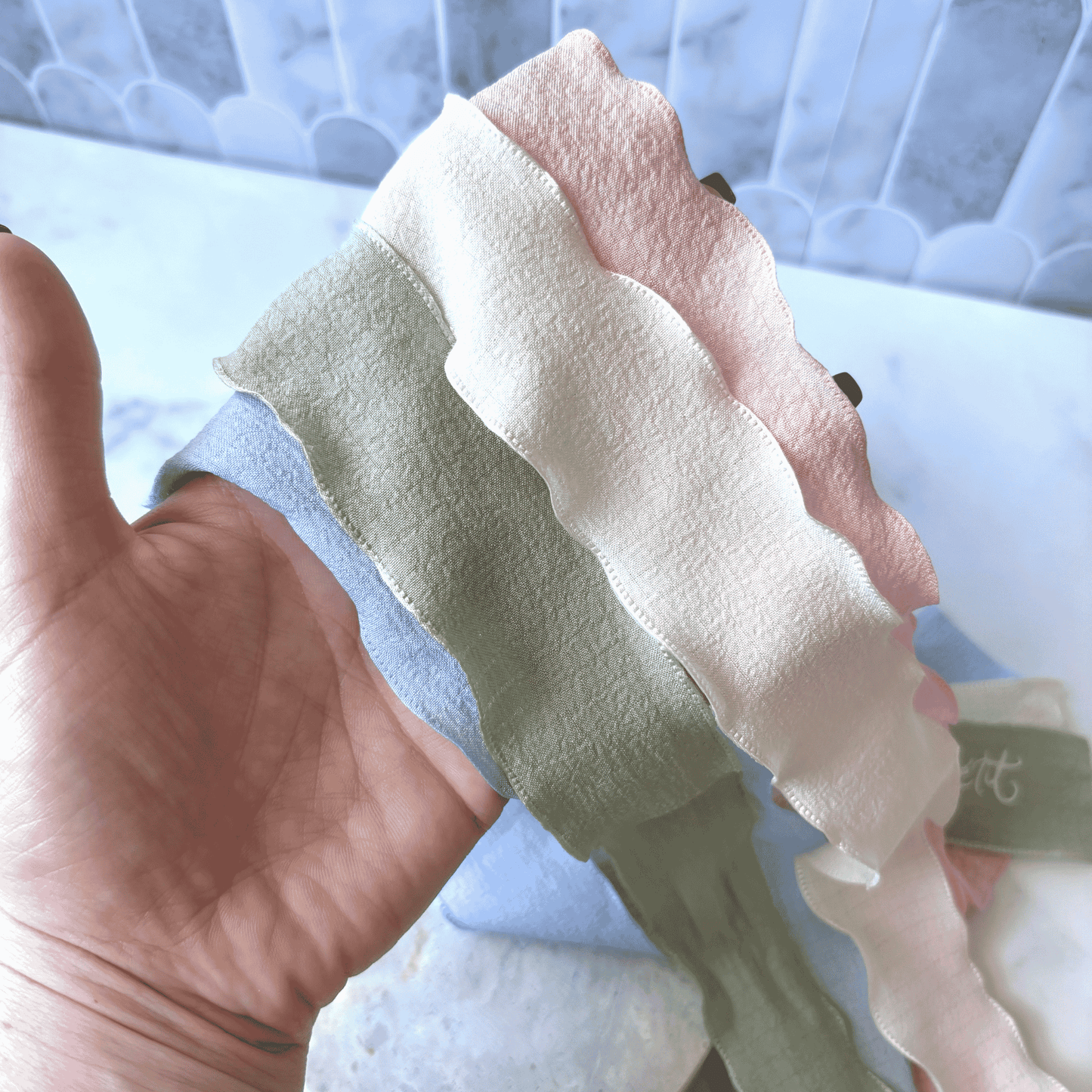 Soft hand-pressed ribbons in wedding colours, custom made for wedding stationery and table styling