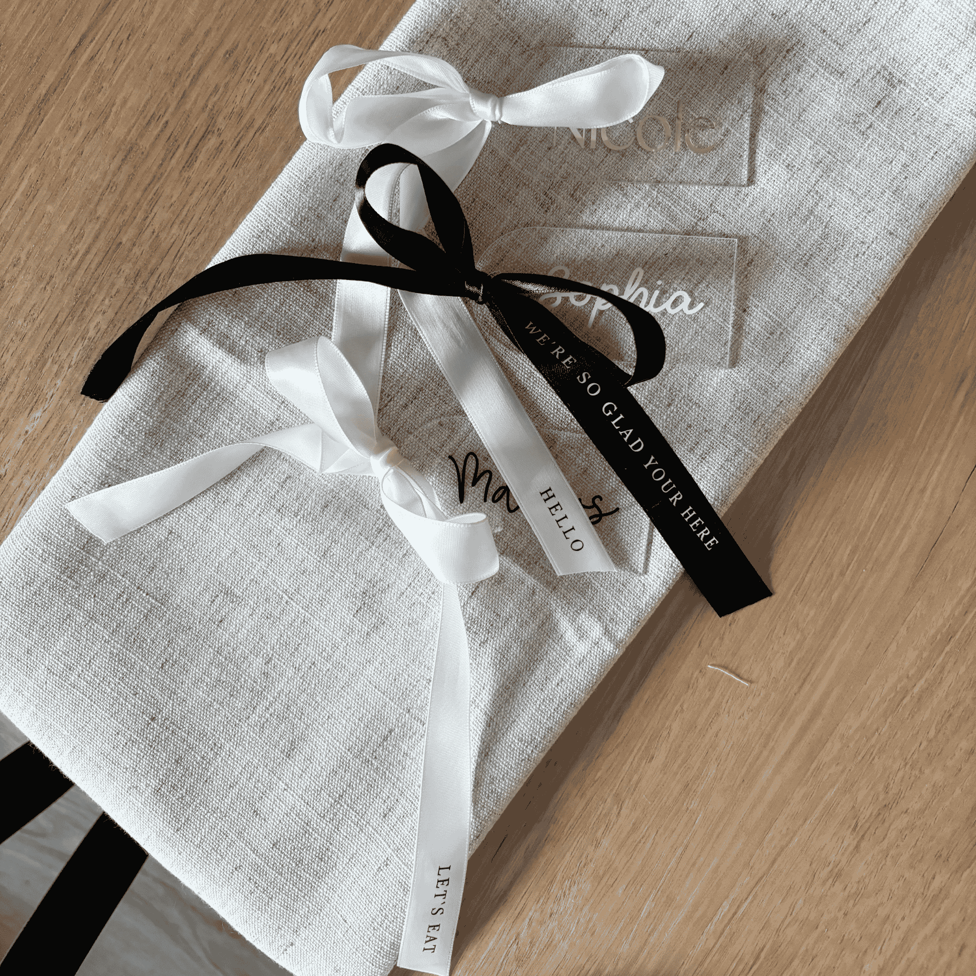 Clear acrylic wedding place settings with black and white ribbon details, styled for modern wedding table settings