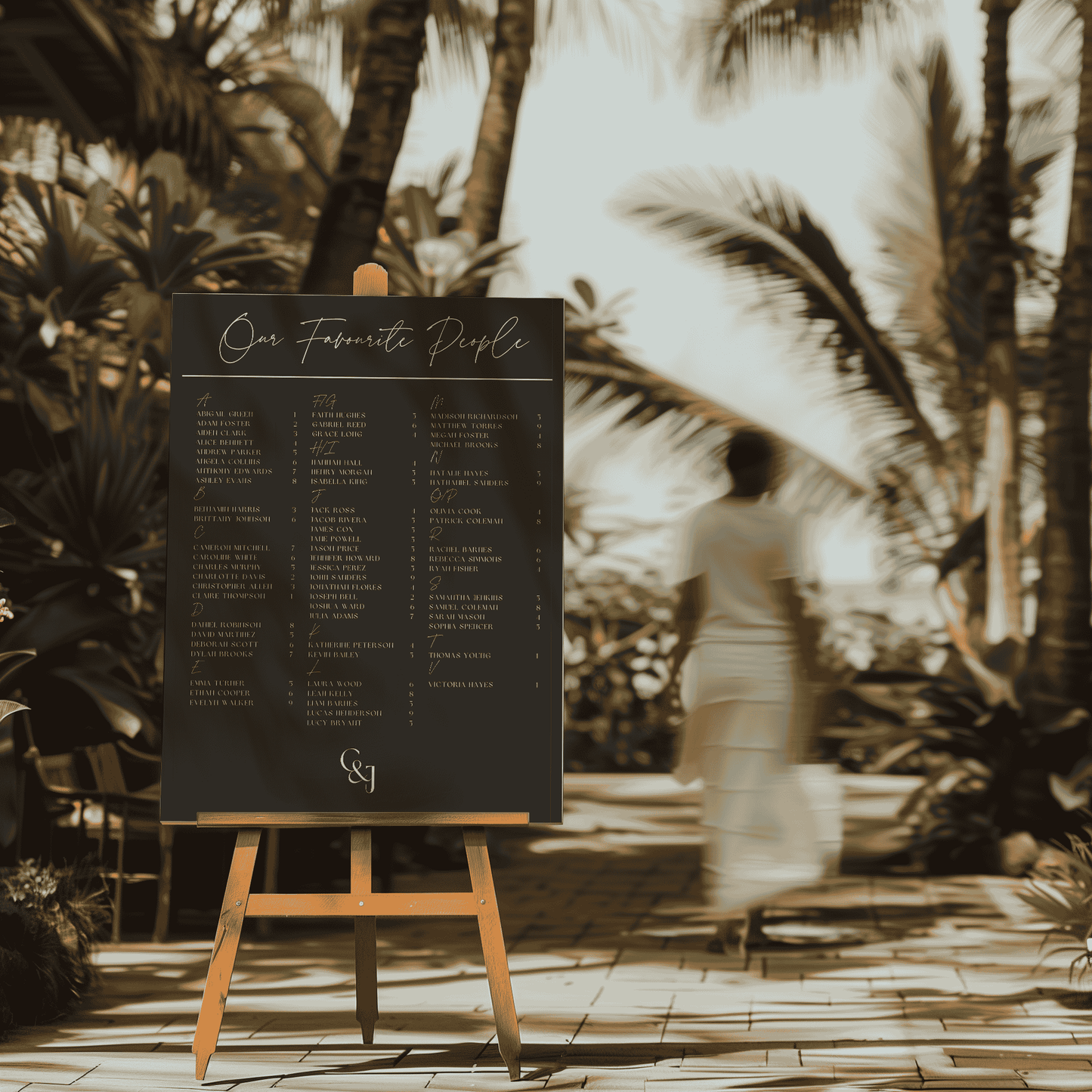 Black Tie wedding seating chart on easel at tropical beach venue, featuring dark background with refined script heading