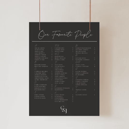 Close-up of Black Tie wedding seating sign with bold black backdrop and gold-toned guest list typography