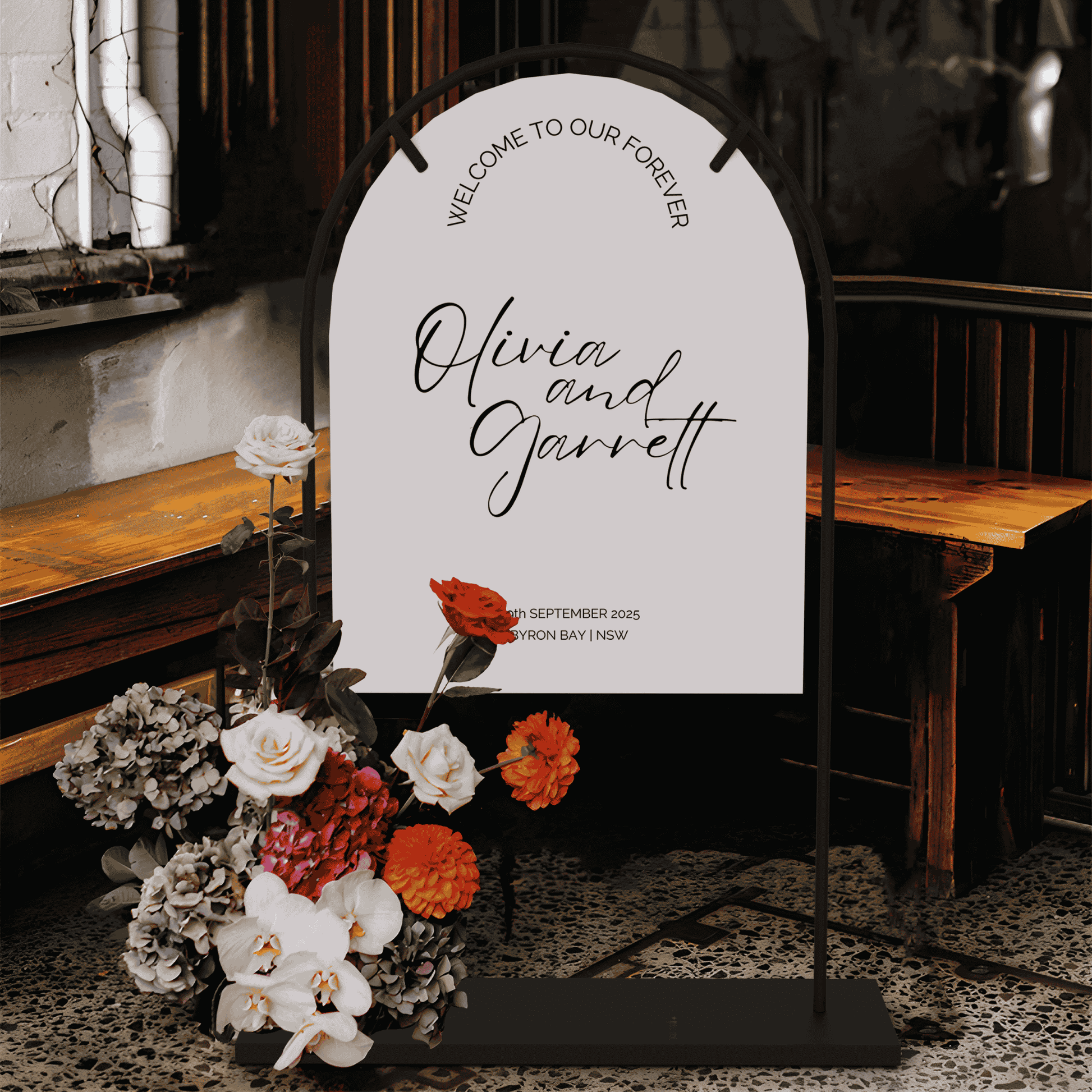 Classic wedding welcome sign with couple names displayed on stand with florals for wedding signage at indoor wedding event