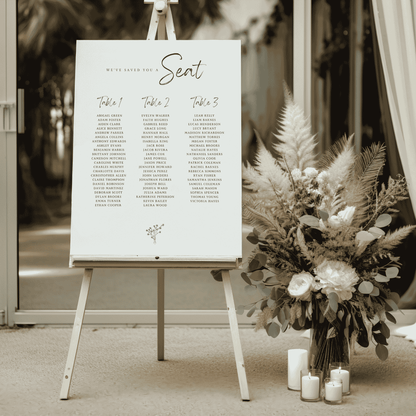Daisy wedding seating sign on easel beside florals and candles for wedding seating charts and wedding decoration