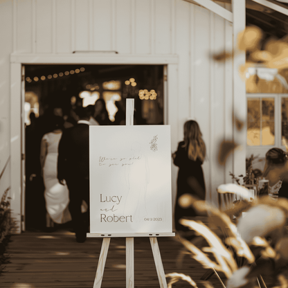 Flora wedding welcome sign on easel at venue entrance welcoming guests to wedding event part of wedding signage