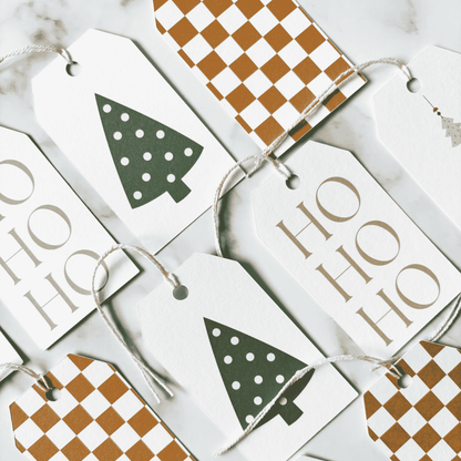 Assorted handmade Christmas gift tags with illustrated Christmas trees and neutral patterns, suitable for wedding favours and gift wrapping