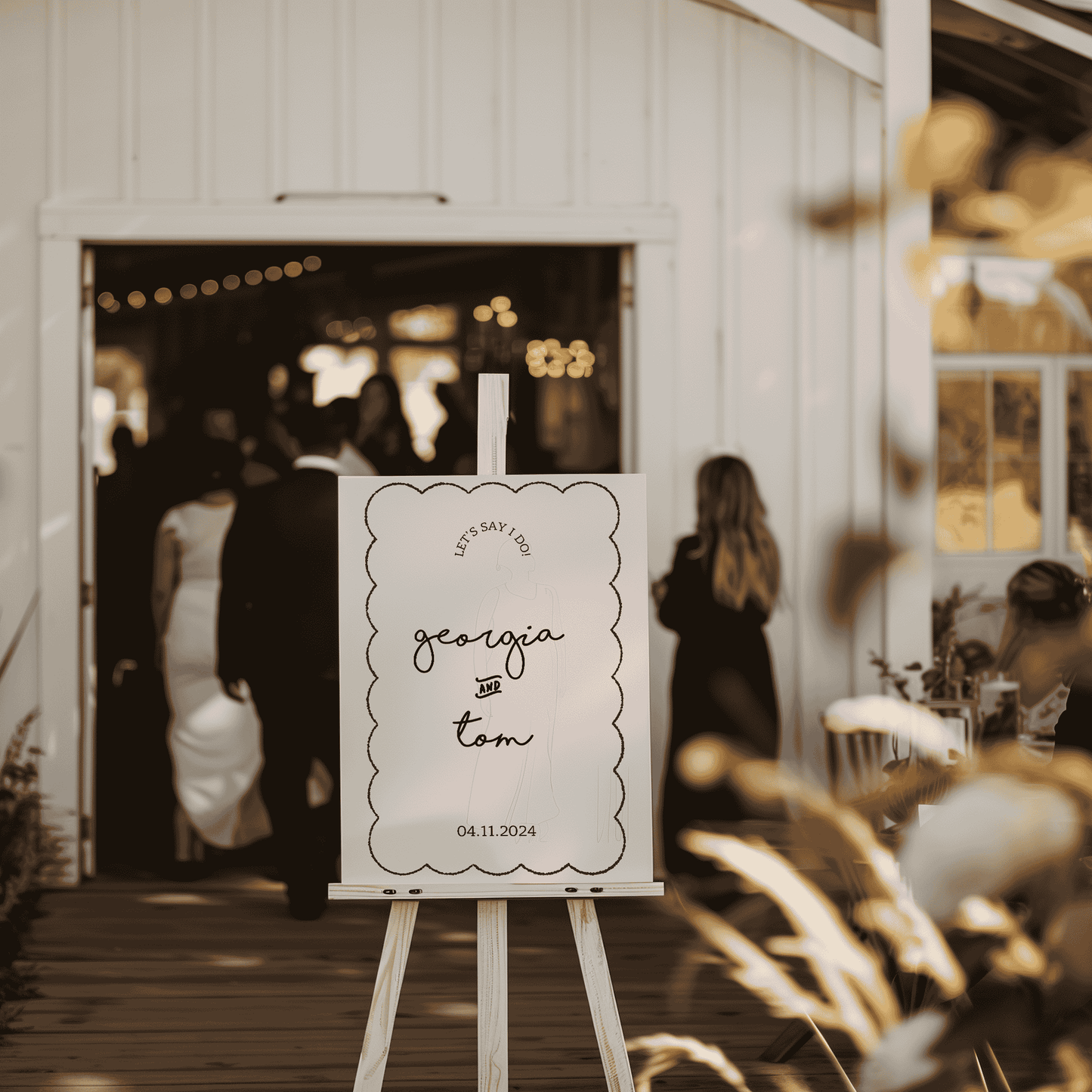 Paris welcome sign styled on easel outside wedding venue entrance with guests arriving