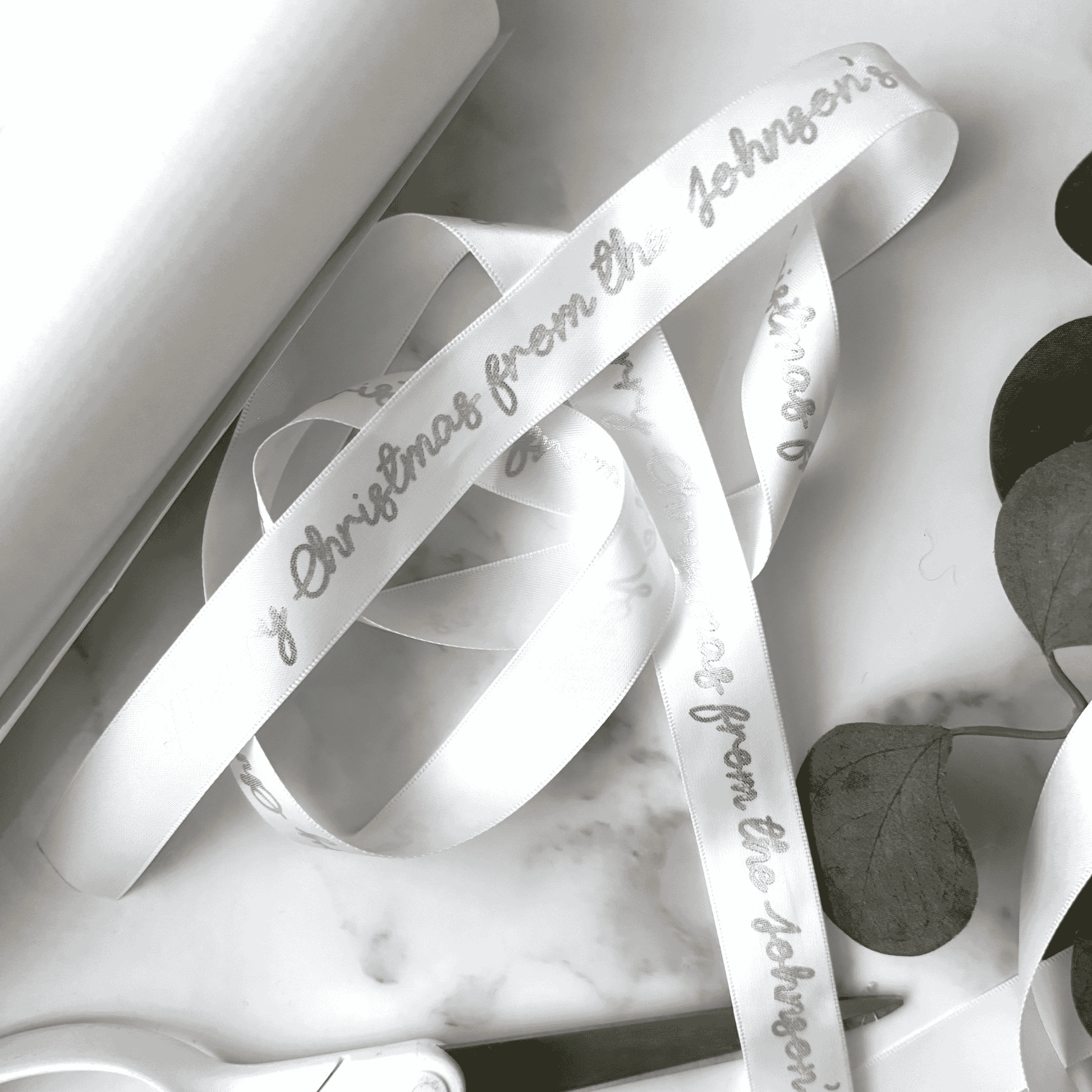 Personalised printed ribbon roll in white with metallic silver text for Christmas gift wrapping