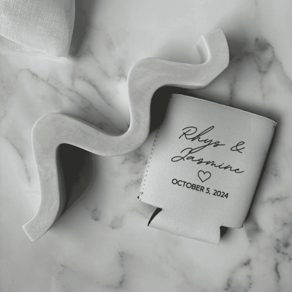 Custom wedding stubby holder featuring names and wedding date, styled as wedding favours alongside modern wedding stationery