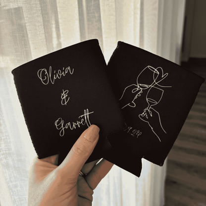 Personalised black wedding stubby holder held in hand showing custom couple names for wedding favours