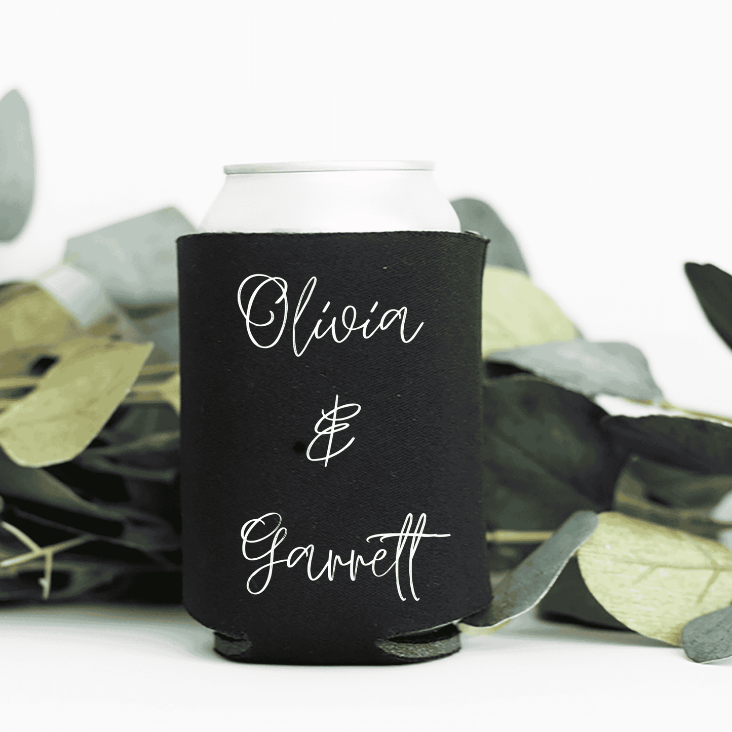 Black personalised wedding stubby holder styled with foliage for wedding favours and wedding event decoration