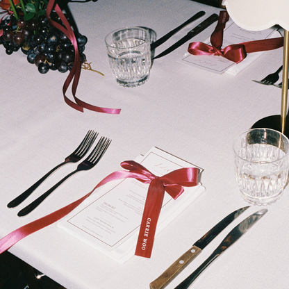 Deep red custom printed ribbon styled on wedding table setting with menu and cutlery