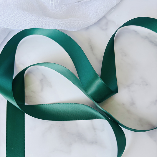 Forest green satin ribbon for wedding stationery and invitation suites, styled on marble surface