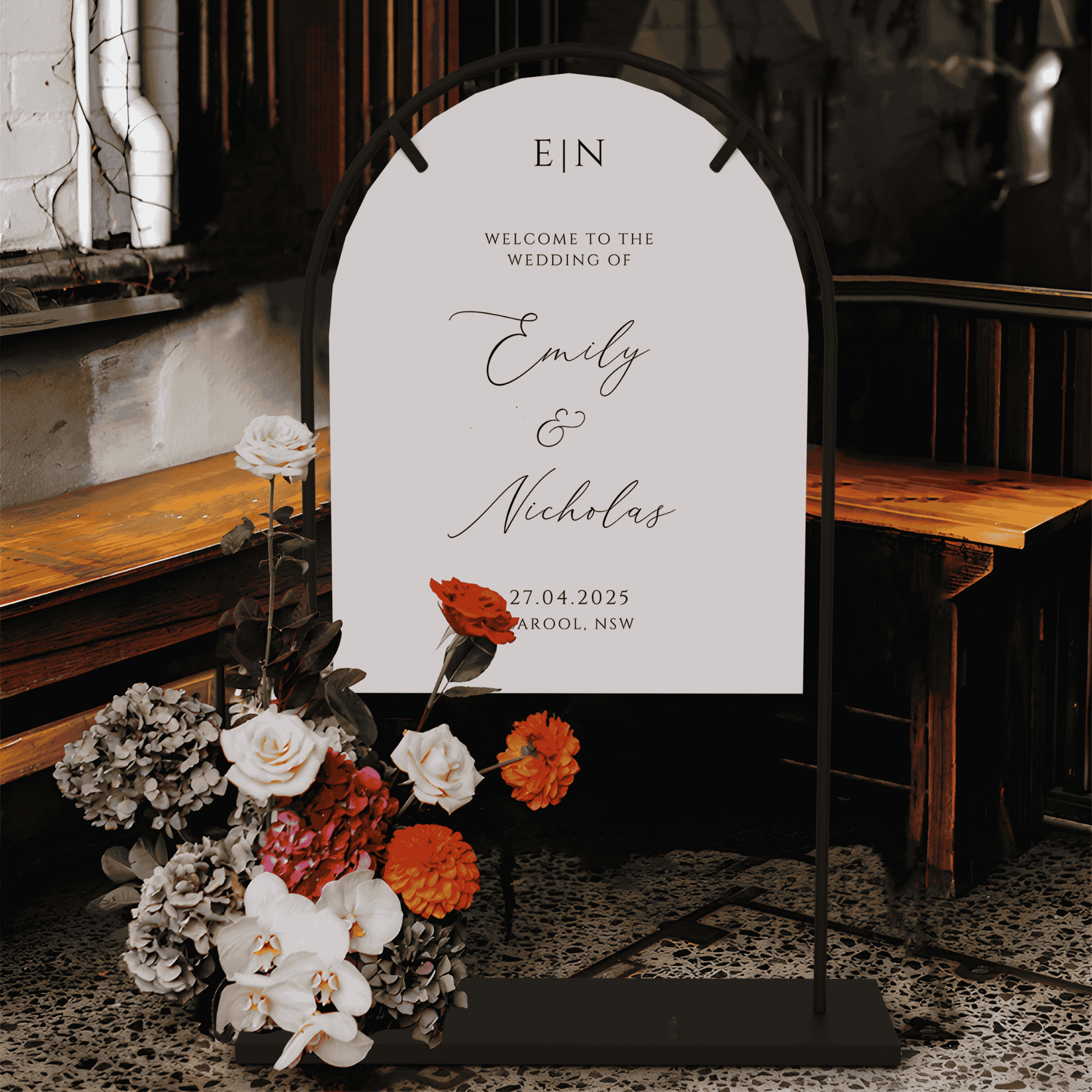 Romance wedding welcome sign displayed on arch stand with modern floral arrangement at indoor reception entrance
